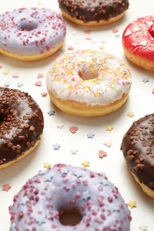 Flat lay with tasty donuts on plain background