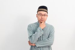Thoughtful Muslim man doing thinking gesture in Ramadan