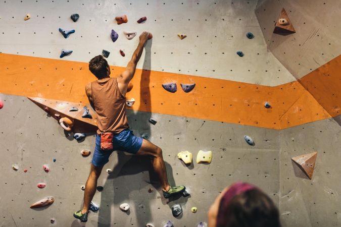 Climber practicing rock climbing at indoor climbing gym