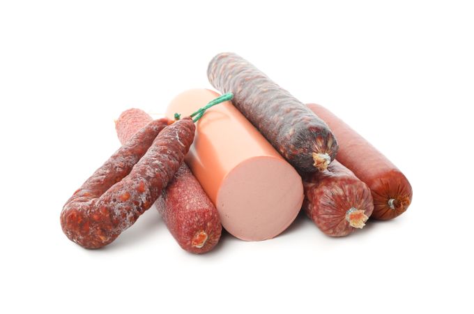 Large variety of tasty cured meats in plain room