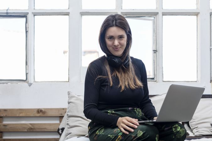 Woman with long hair sitting with laptop at home