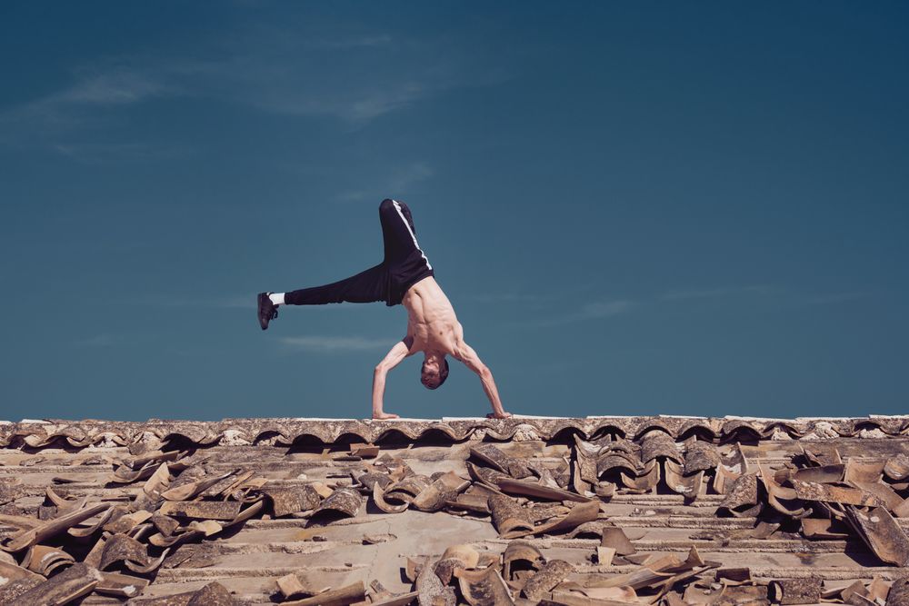 Flexible young man performing two hands rotation while dancing breakdance