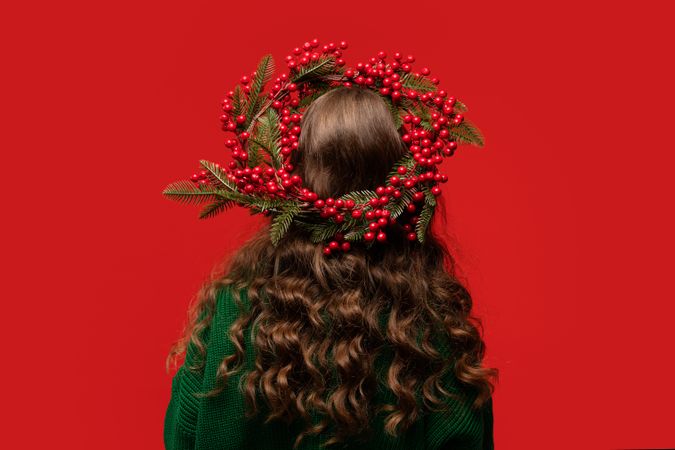 Teen girl wearing Christmas berry wreath with curly hair