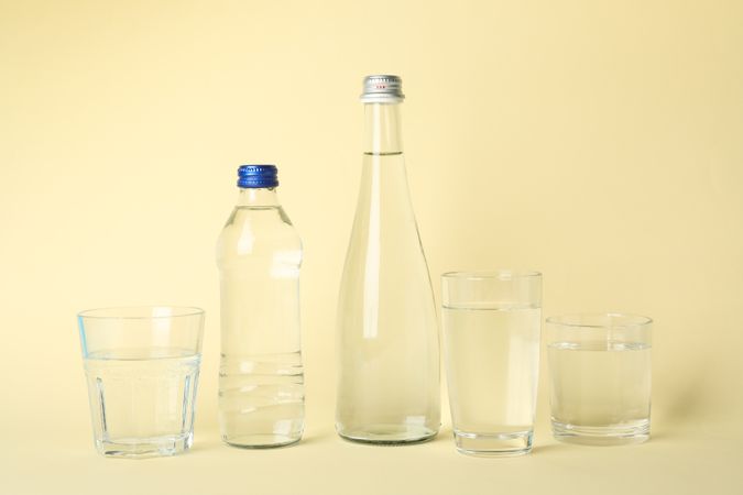 Plastic and water bottle with glass in beige room