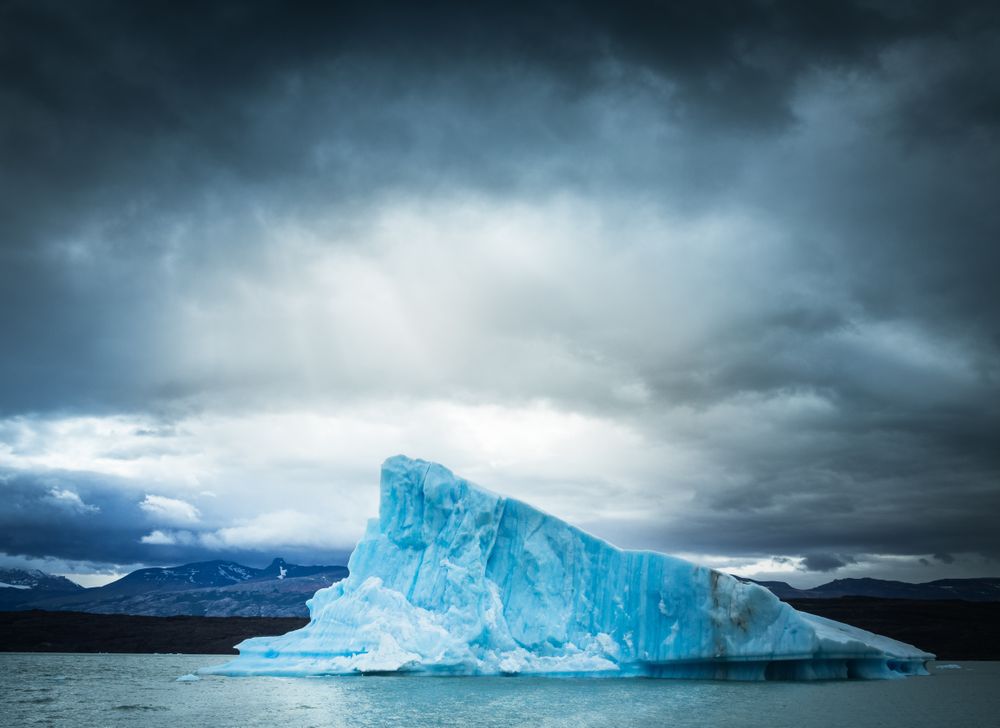Iceberg against overcast sky