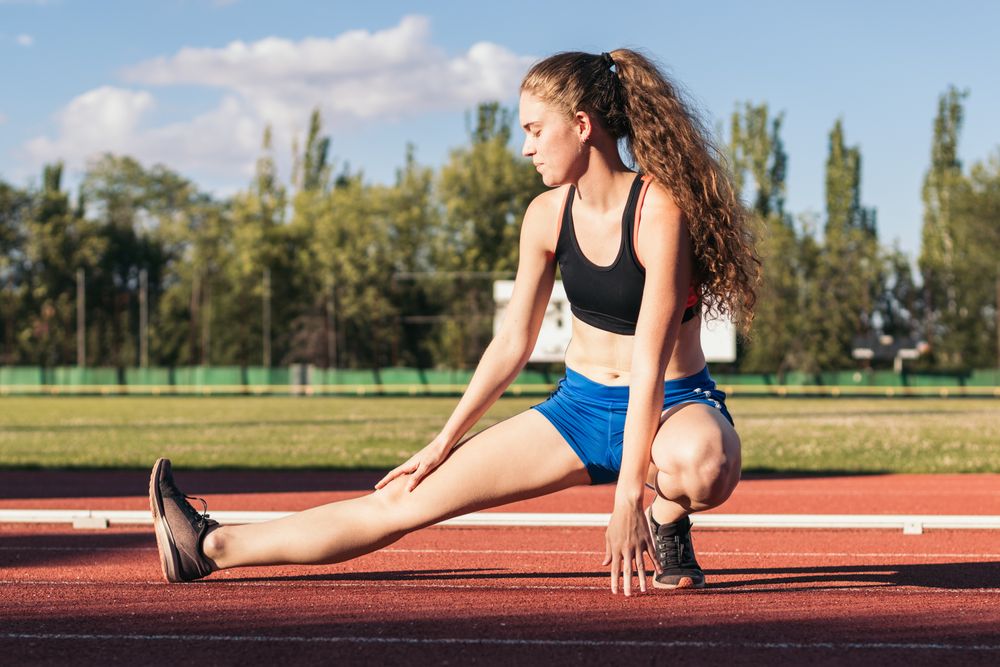 A female athlete warming up before running.