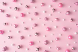 Different shades of pink and light-colored baubles on a pink background