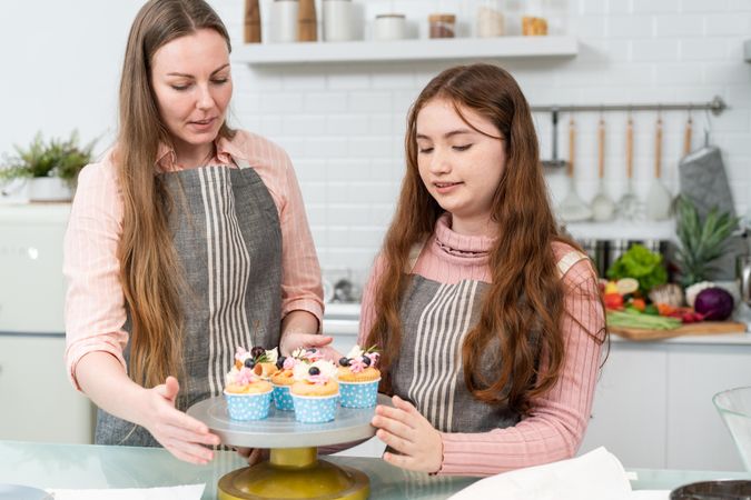 Mother teaching daughter baking in kitchen