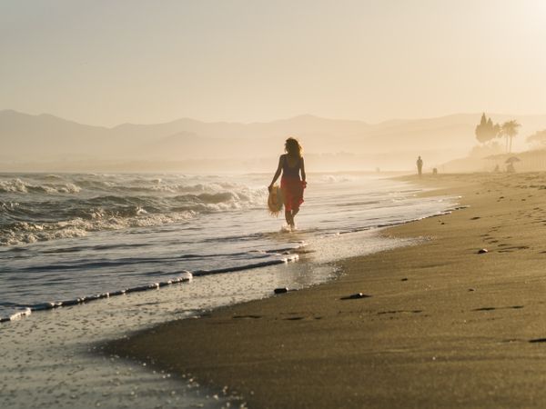 Woman holding walking along seaside