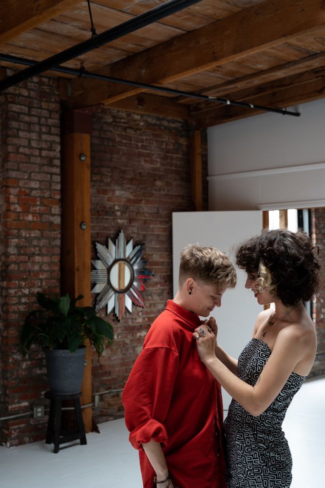 Young woman buttons her partner’s shirt