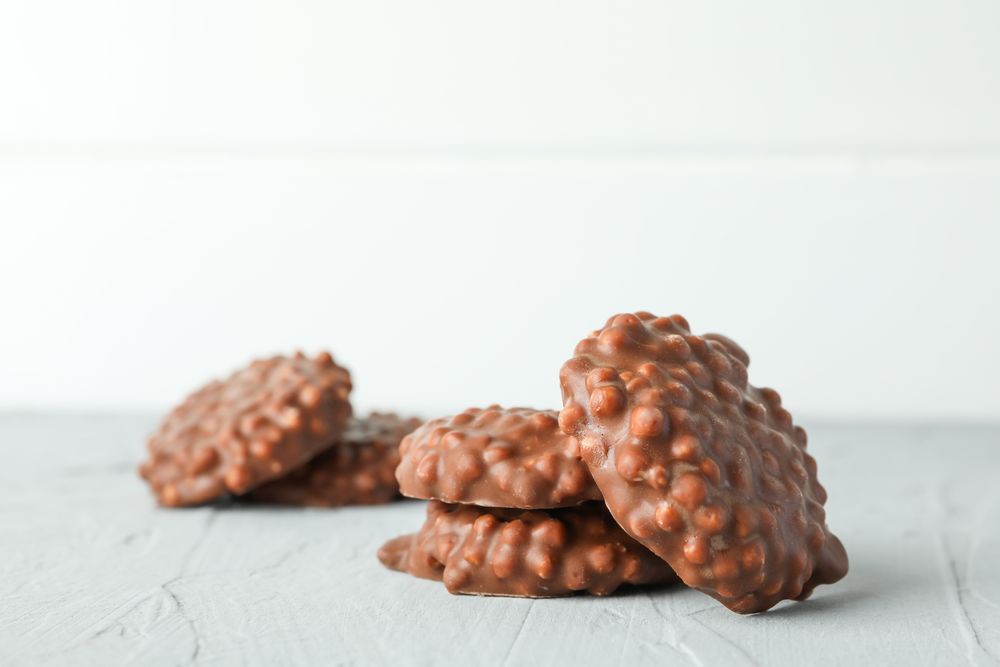 Chocolate cookies on grey table against light background, space for text