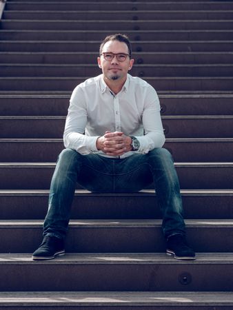Content man sitting on stairs
