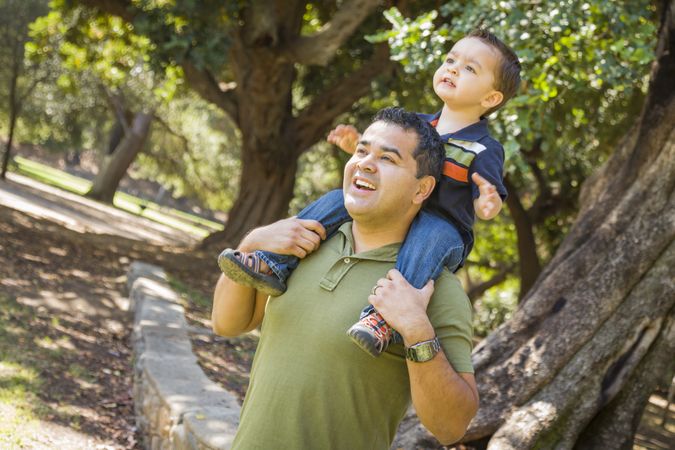 Son Enjoy a Piggy Back in the Park with Dad