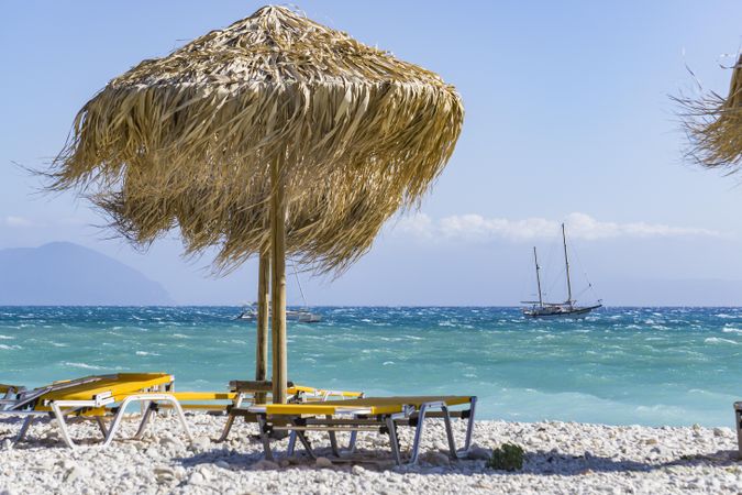 Beach chair and straw umbrella on seashore
