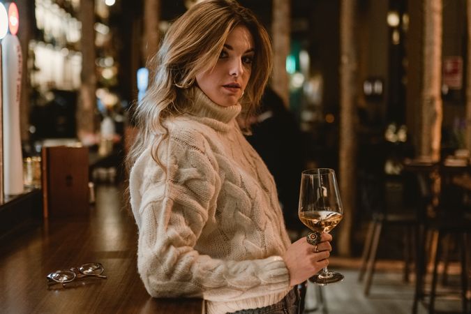 Stylish woman drinking wine in bar