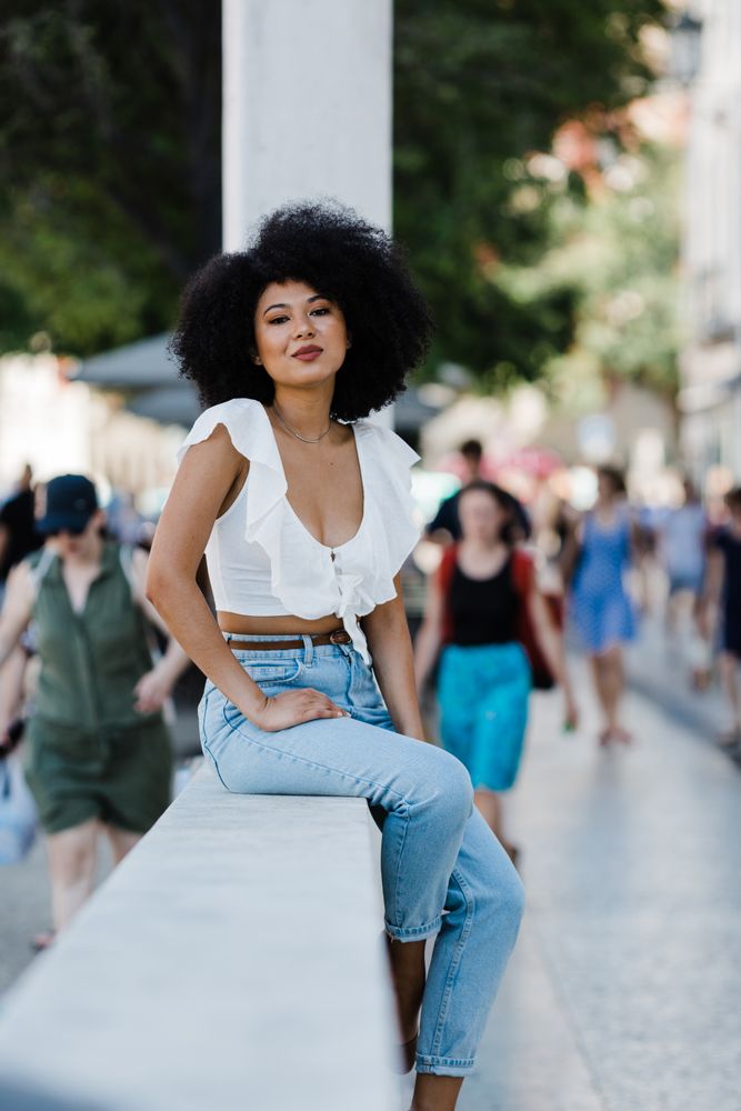 Black female sitting on concrete parapet