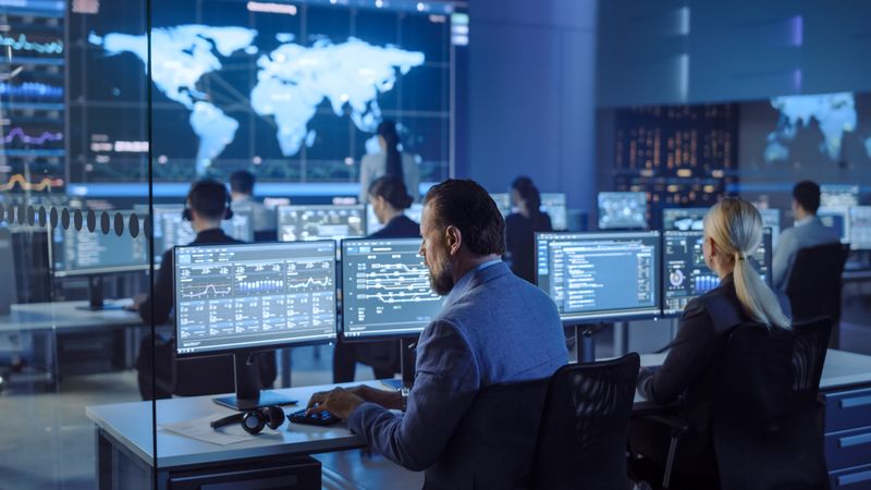 Global Operations Center With Analysts Monitoring Data on Multiple Screens.