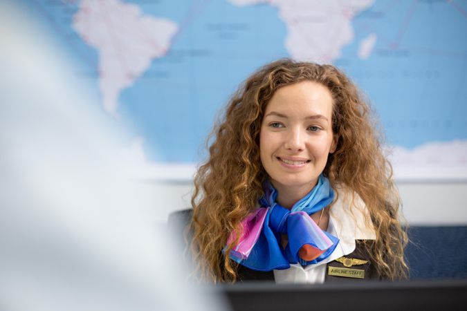 Happy woman working with traveler at airport check in