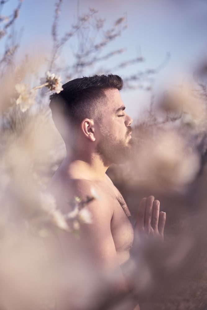 Shirtless man meditating in spring garden