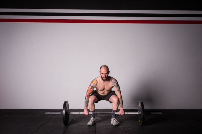 Man lifting barbell in gym