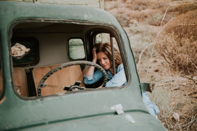 Relaxed female leaning on old truck