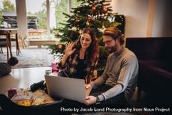 Couple using laptop for video calling their family on a Christmas day bxmOv0