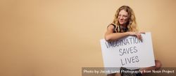 Woman holding a banner with ”vaccination saves lives" slogan 4132O0