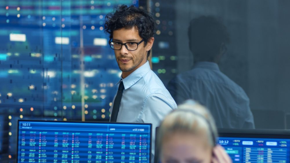 Stock Trader Inspects Others Work and Chat with Other.