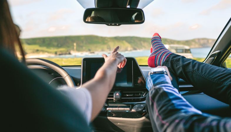 Young couple traveling by car feet up barefoot
