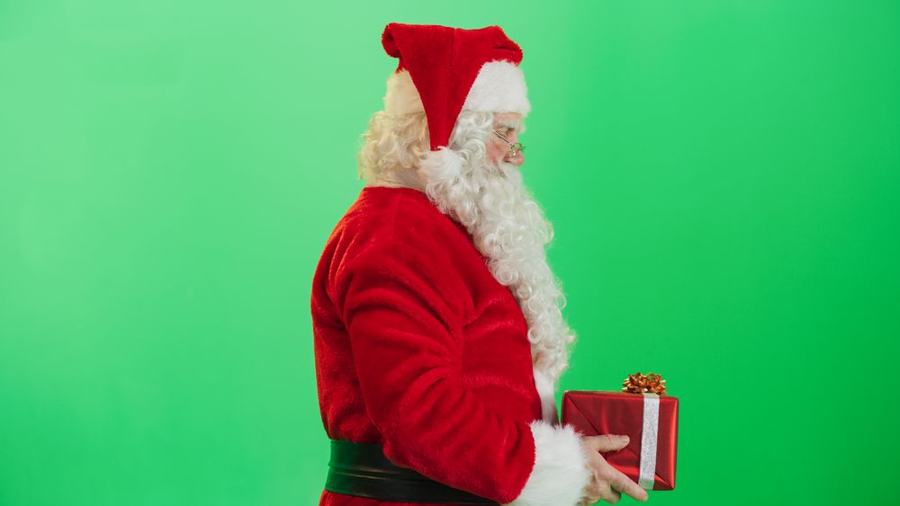 Studio Shot Isolated Mockup Template: Jolly Santa Claus Offering Beautifully Wrapped Gift To Children On Green Screen Chromakey Background. Concept Of Christmas, New Year, Celebration
