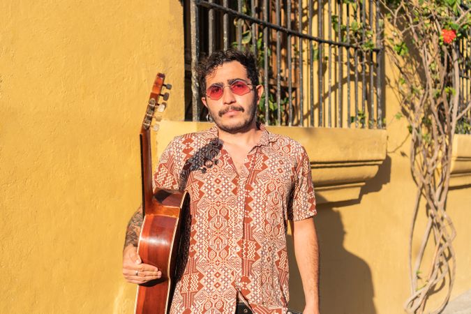 Street musician standing in the street holding his guitar