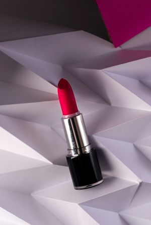 Pink lipstick on raised chevron. Product and make up contemporary concept