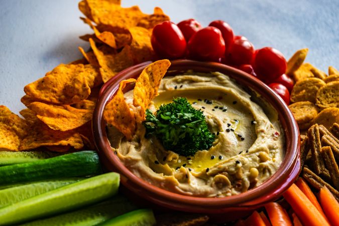 Traditional hummus dish served with fresh veggies and chips