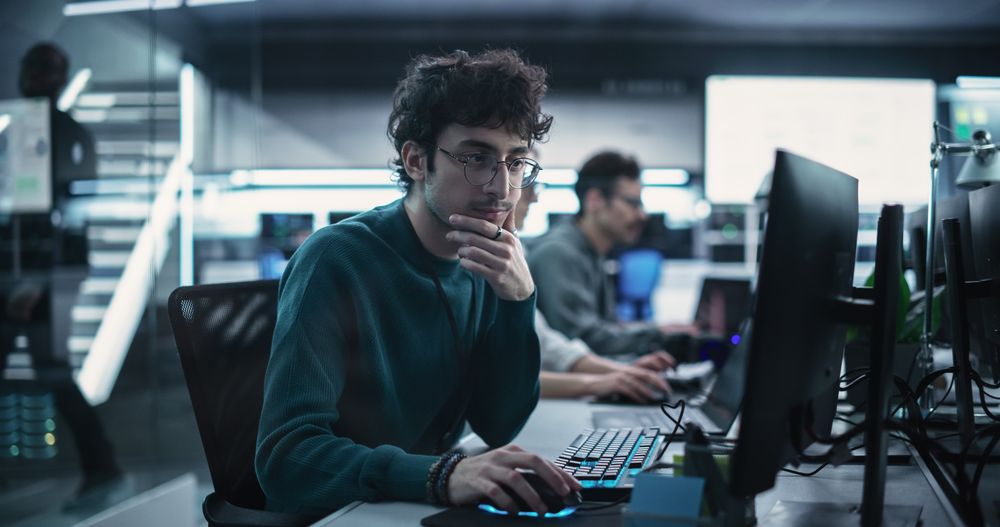 Portrait of a Thoughtful Engineer Working on Desktop Computer in a Technological Office Environment.