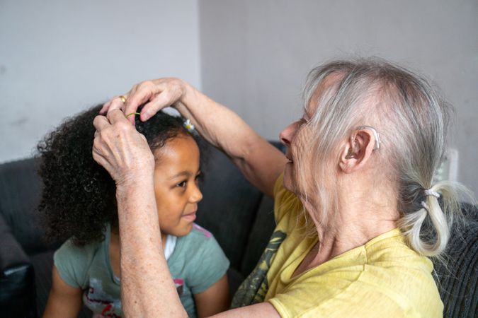 Older woman doing hair of grandchild