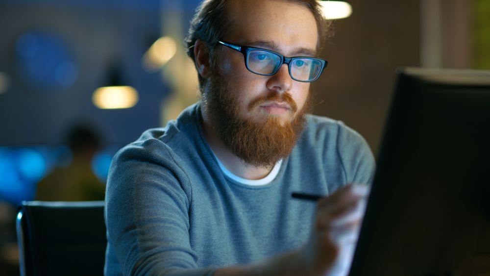 Talented Young Concept Artist Drawing on a Digital Pen Display Tablet While Sitting at His Working Place in Modern Loft Office.