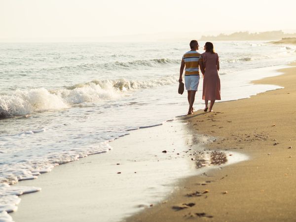 Adult couple walking towards sea