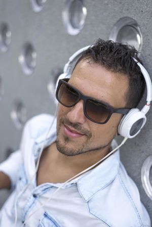Man sitting outside while listening using headphones