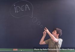 Boy standing at board with "idea" written in chalk 5l1XM4