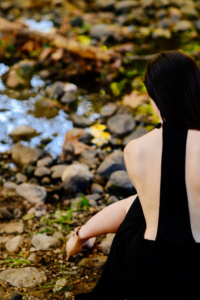 Back view of woman in formal  dress with shoulders showing and her leg stretched out
