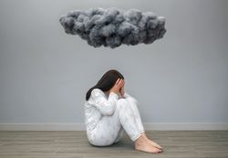 Woman covering her face with hands under a dark storm cloud
