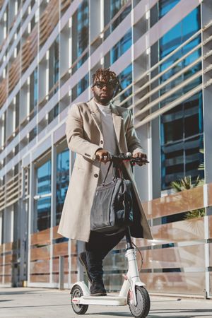 Black man riding electric scooter