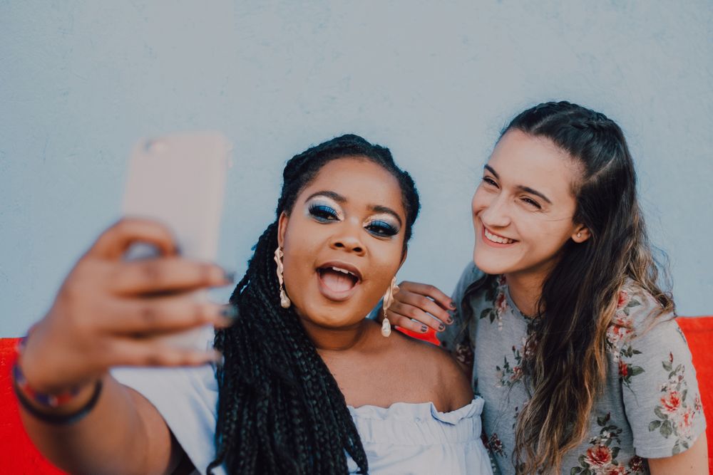 Smiling multiethnic women taking selfie