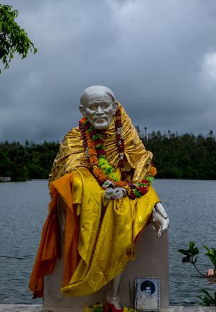 Yellow Saw Baba statue on a cloudy day