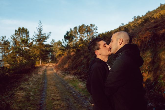 Smiling men hugging on countryside road