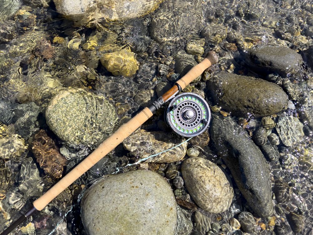 Fly fishing rod and reel on flowing river bed