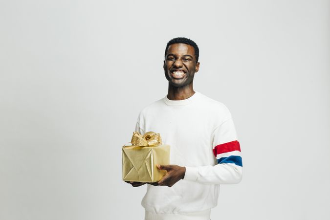 Happy Black man holding gold box in his hands