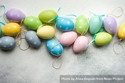Easter festive card concept with pastel egg decorations on grey table 0WOXLP