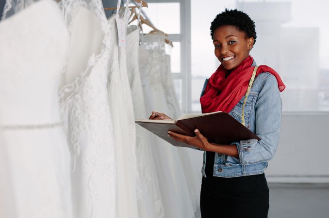 Female bridal wear designer with diary working in boutique