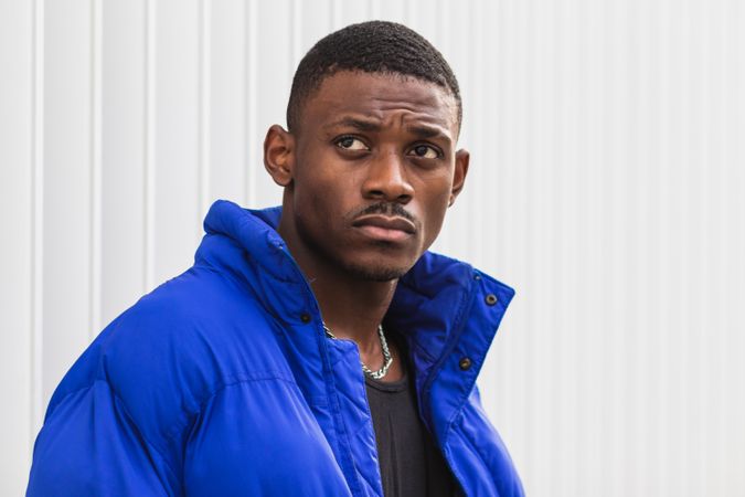 Black stylish man in warm jacket on street